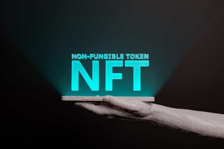 NFT illuminated word on the screen of a mobile phone held by an electronic hand. metaverse concept, nft, play to earn, crypto, blockchain and technology. 3d rendering